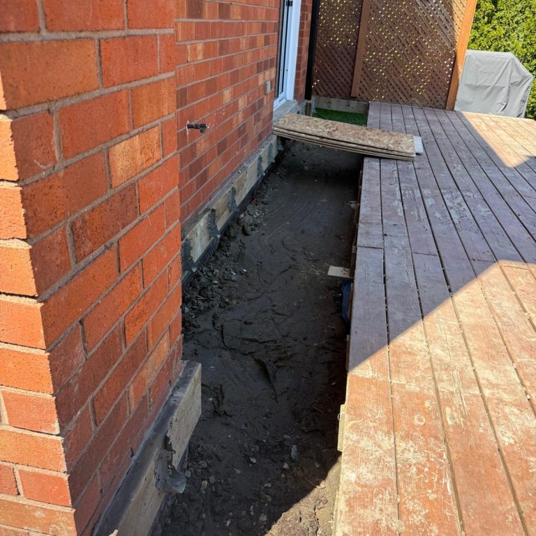 Excavated area beside wooden deck.