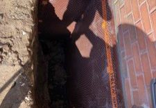 Excavated area for waterproofing installation.