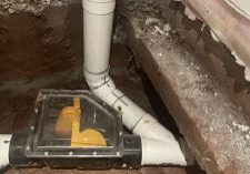 exposed plumbing in a basement, showing a Backwater valve that is low maintenance